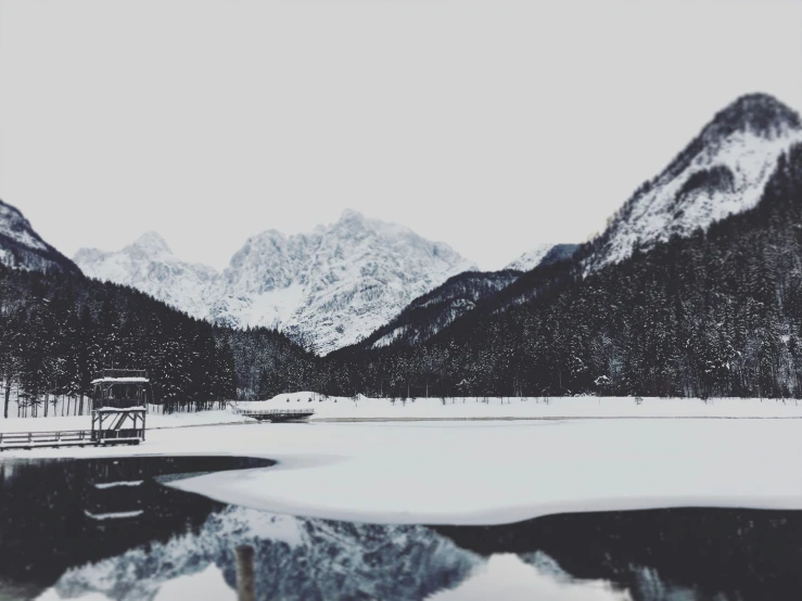 a view of some mountains and a lake in the snow