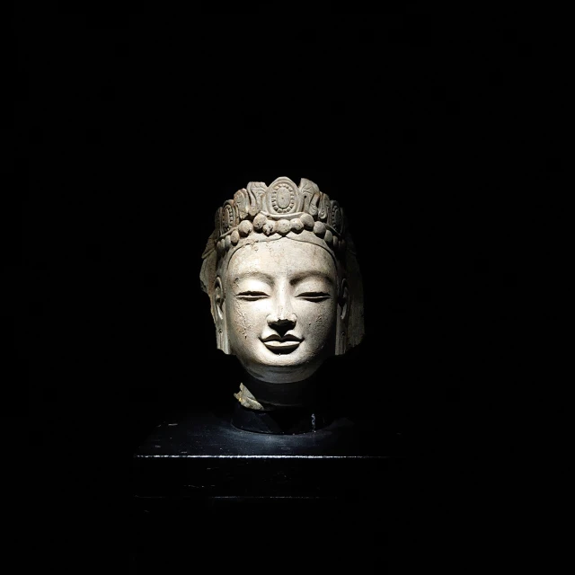 the white head of buddha in a dark room