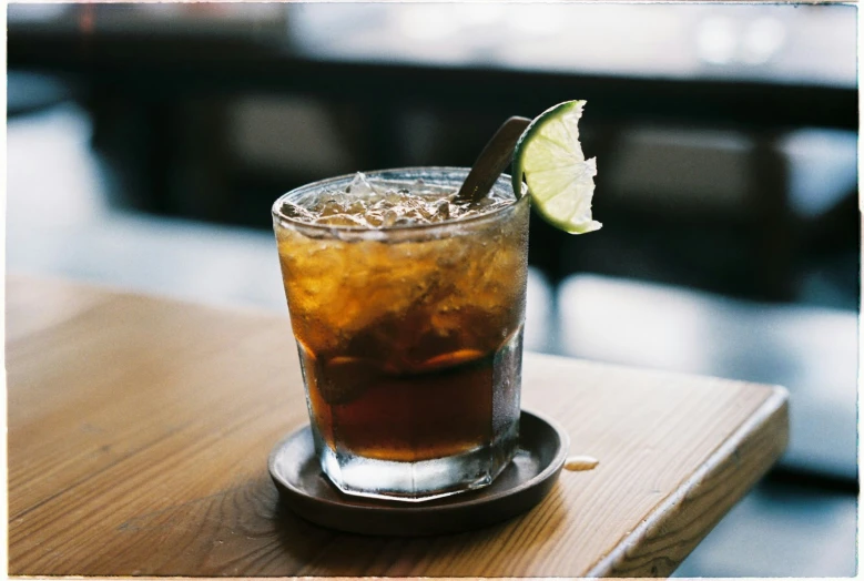 an old fashioned cocktail with a lime wedge in the middle