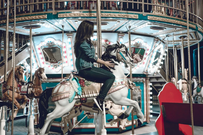 a woman on a merry go round with horses