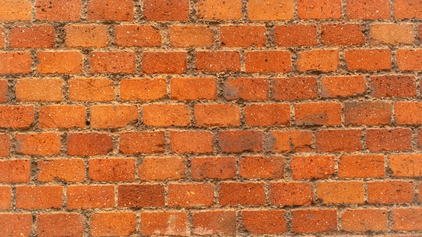an orange brick wall with several different colored patches