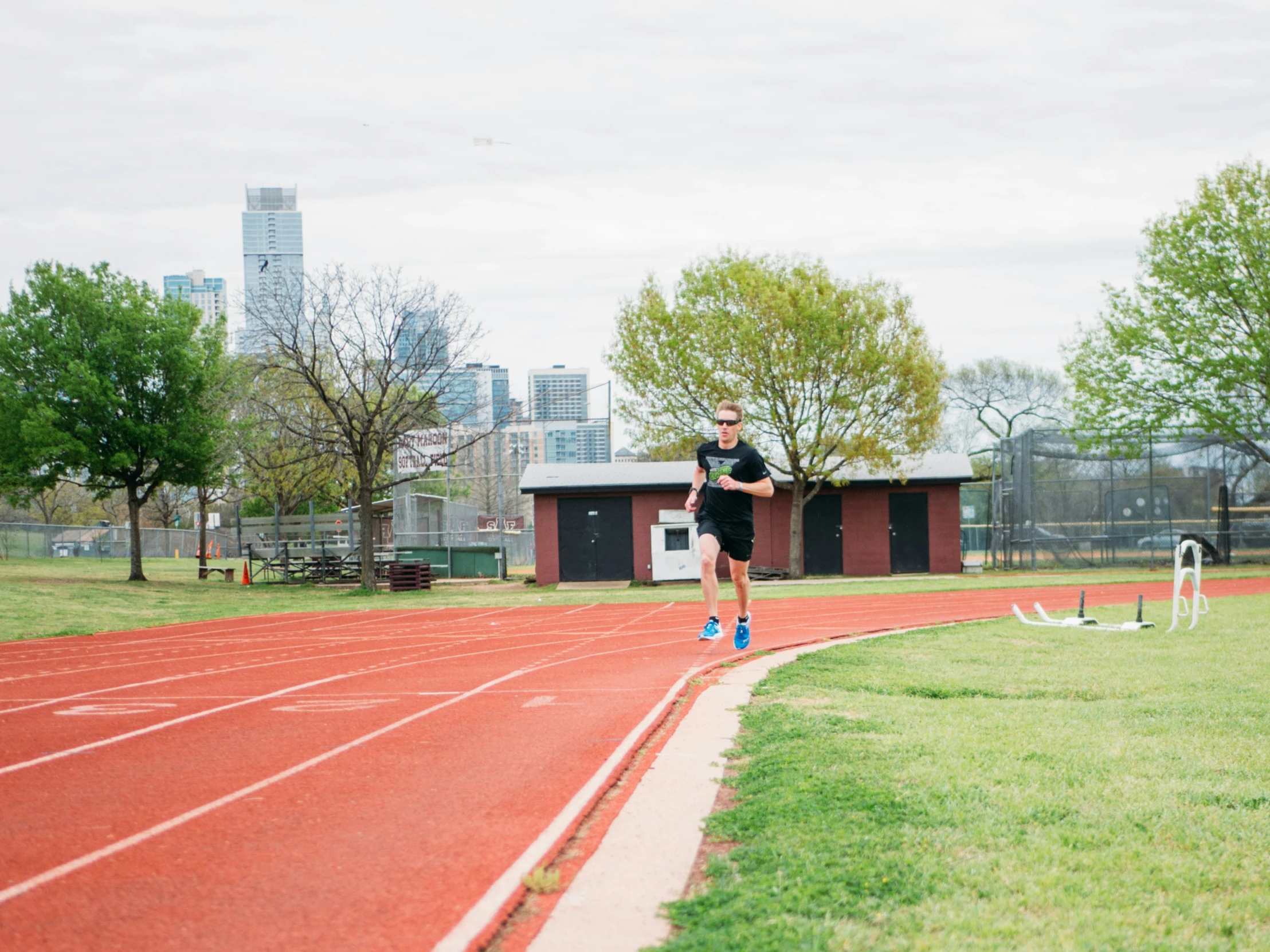 a man in black shirt running on a red track