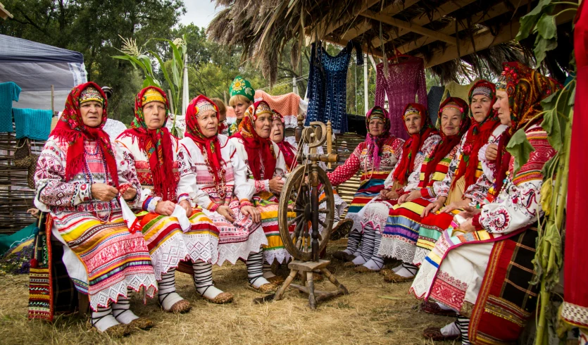 a group of people in colorful attire on a dirt field