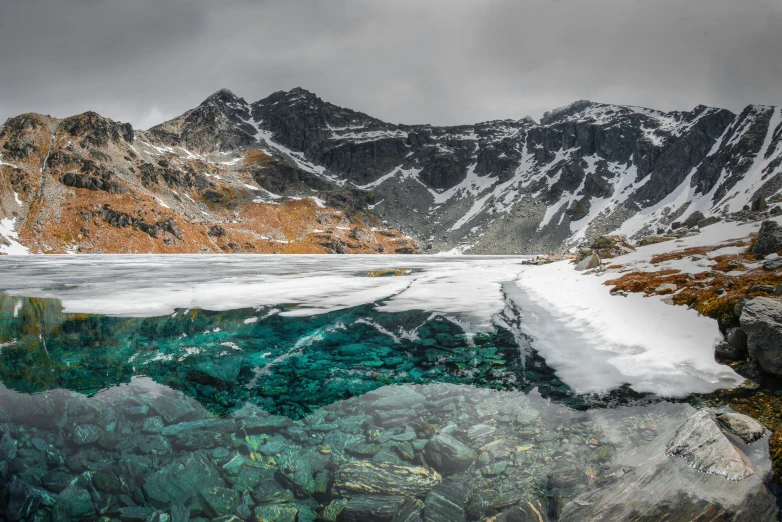 the mountain range is reflected in a body of water