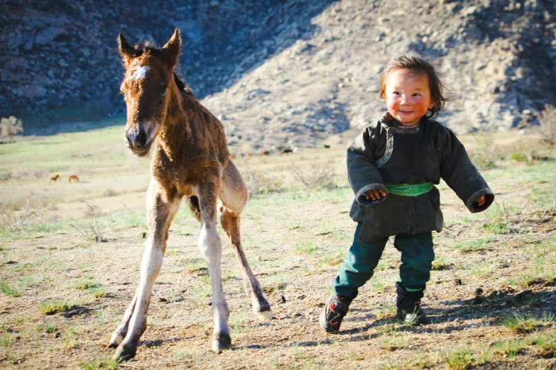 the  is standing next to a small pony