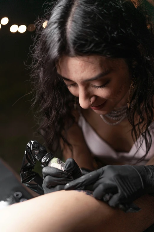 woman in white shirt putting soing into a black glove