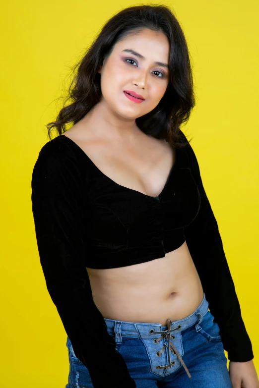 a pretty young lady standing in front of a yellow background