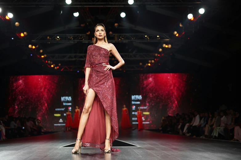 a woman walks on the runway at a fashion show