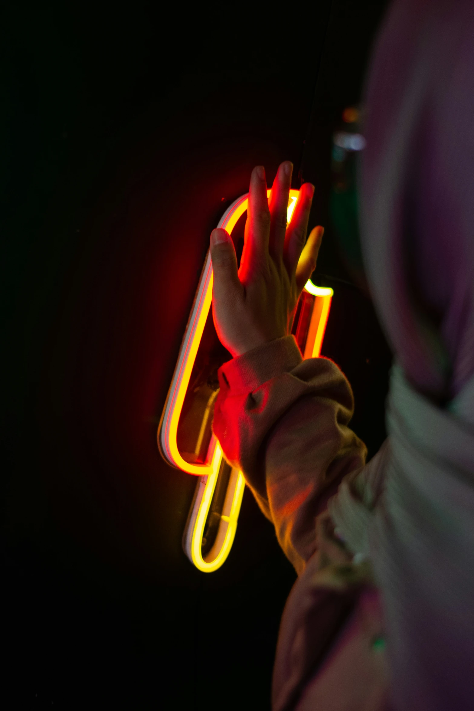 a person holding a neon object up in the dark