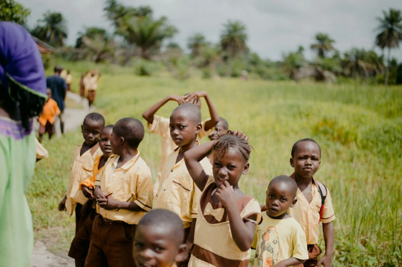 a group of s stand together in front of grass and trees