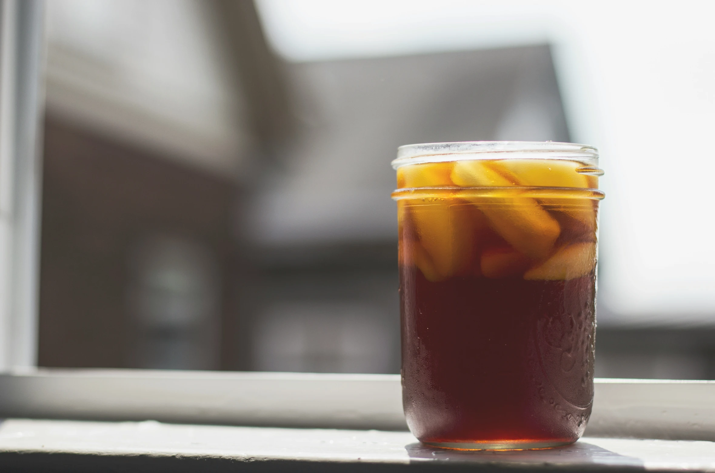 a glass filled with food and sliced up peaches