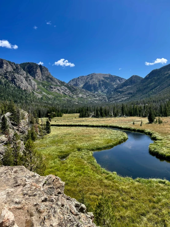 an expansive mountain scenery with a creek running through the center