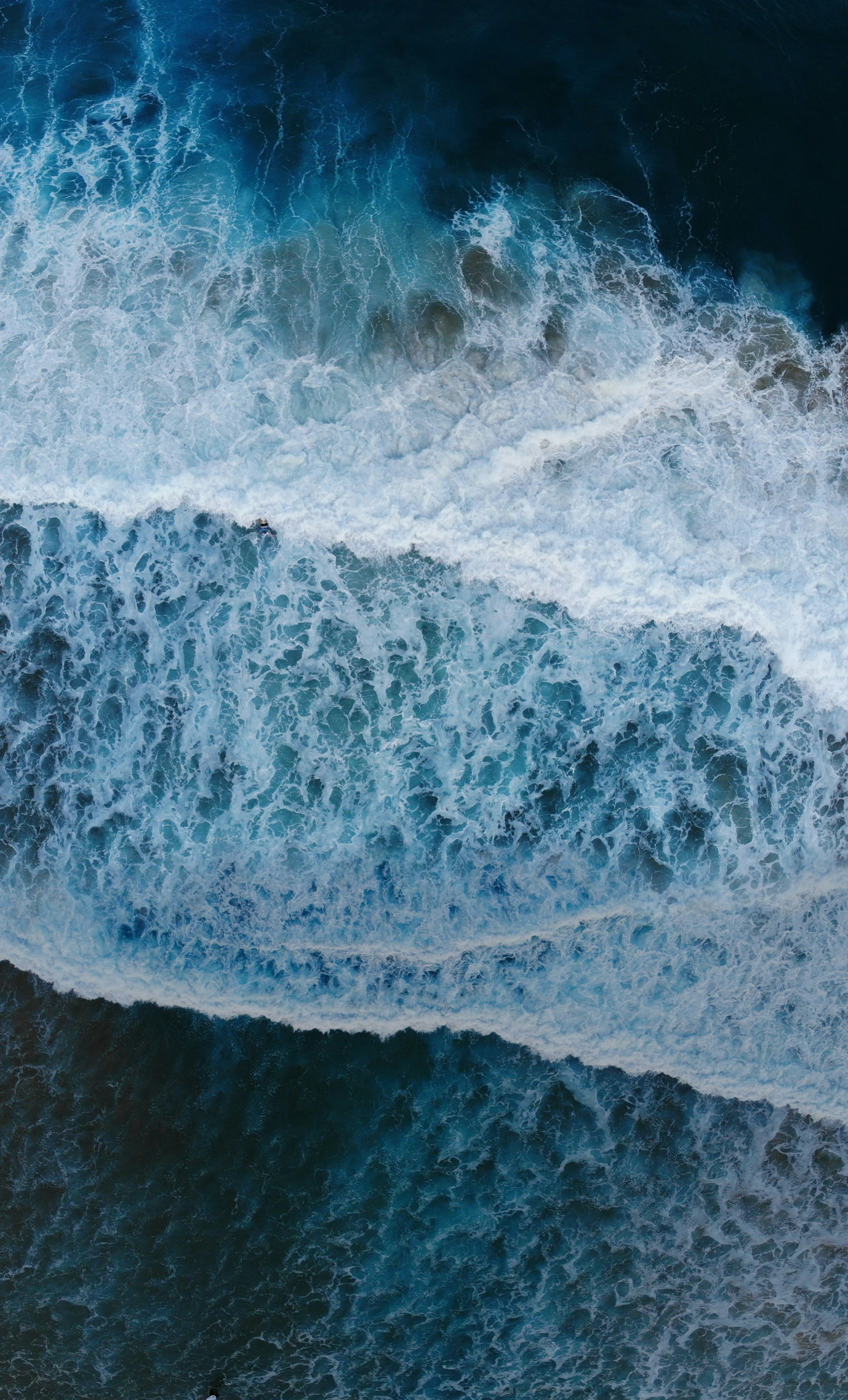 two blue waves are next to each other on the ocean