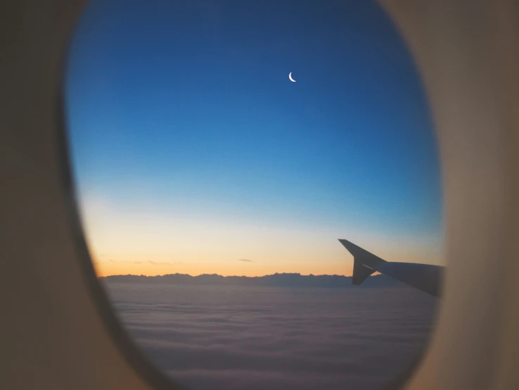 the view through an airplane window at sunset