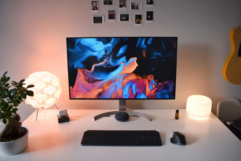 a desk with a laptop, keyboard and monitor