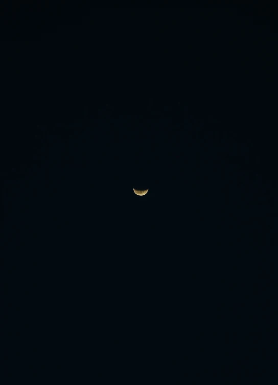 a moon shining through a black sky with a smaller moon in it