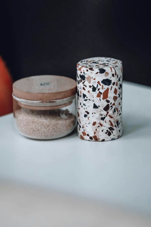 a jar full of powder next to a container of a roll