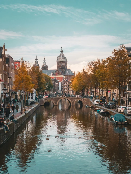 an overview of some people sitting on a bench overlooking a canal with boats