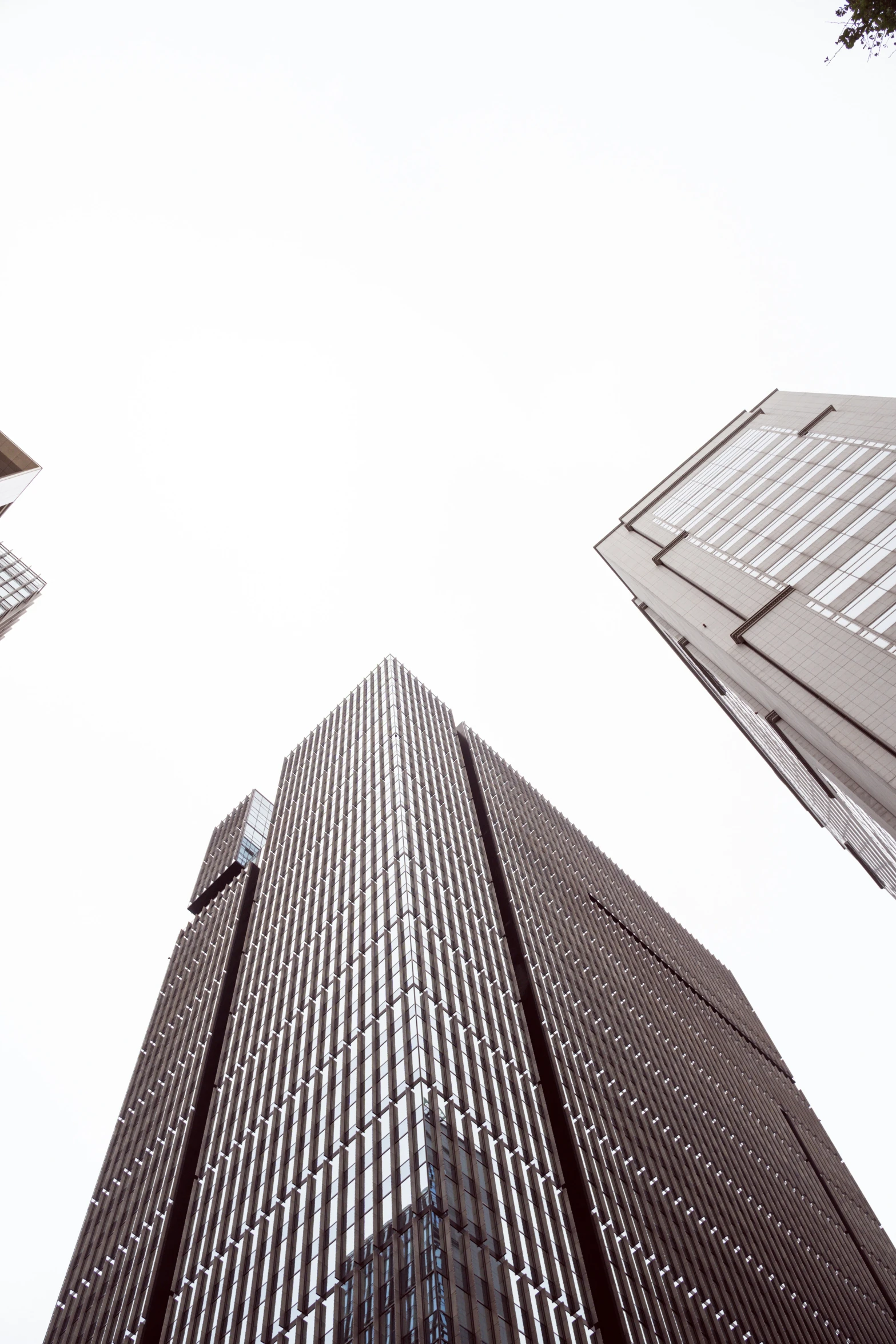 three skyscrs and a person walking in the street