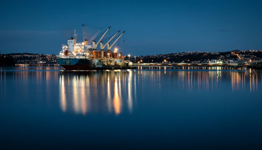 a large ship on the water near lights