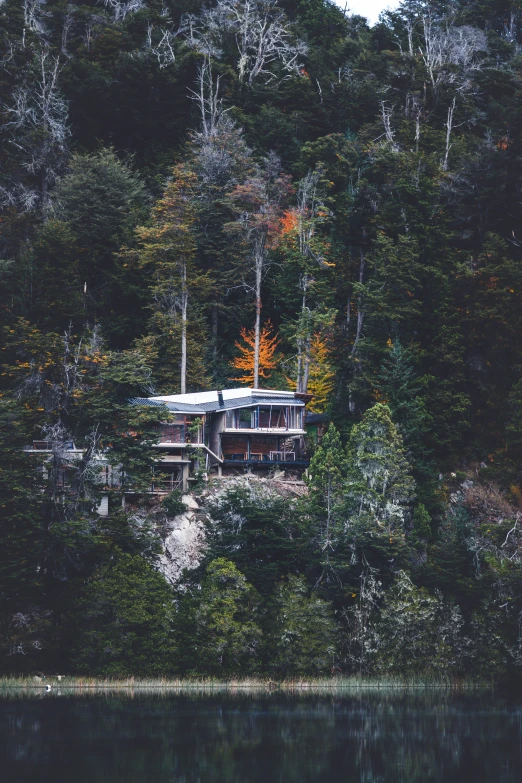 an unusual looking home nestled on the edge of a lake