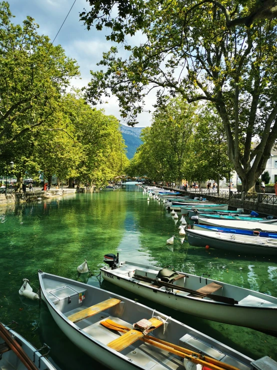 a row of boats sitting on the side of a river