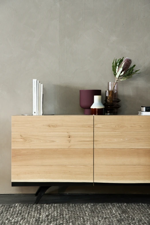 a shelf with some books on top and a vase