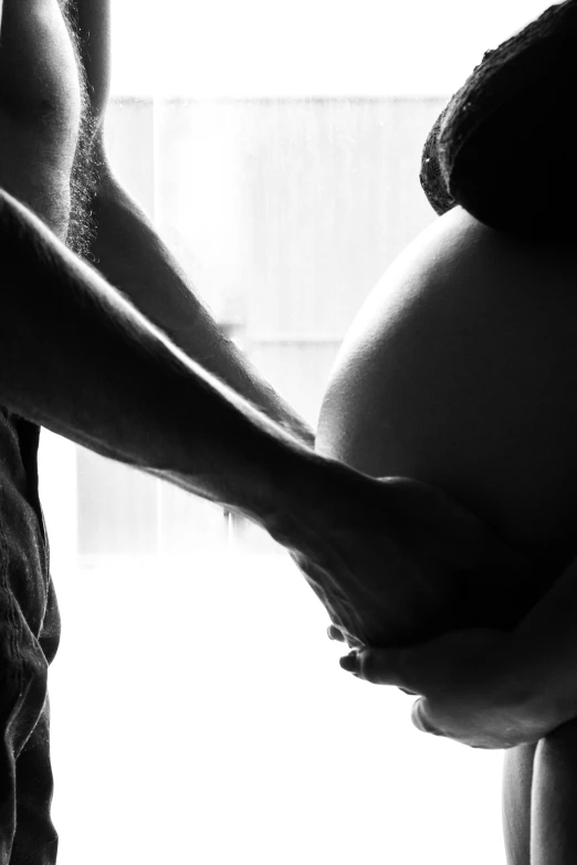 a person holds the side of a pregnant pregnant woman