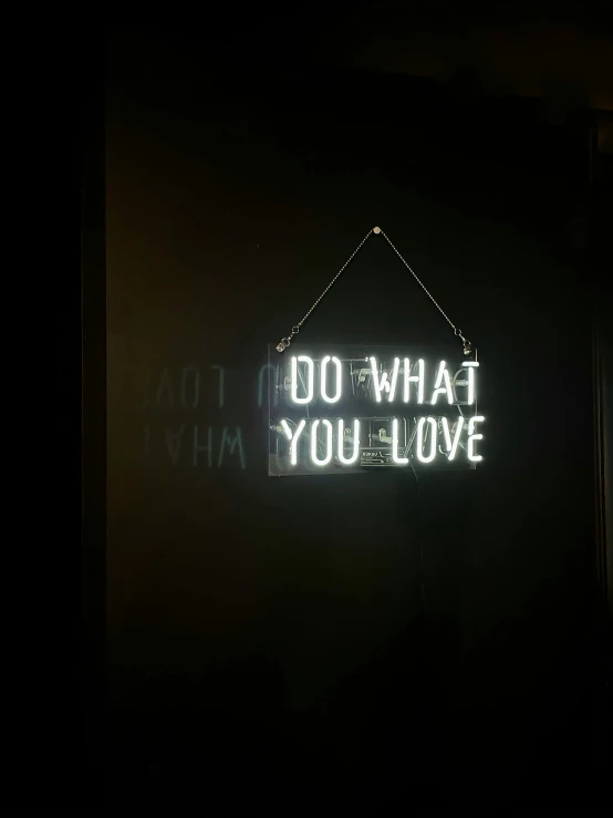 neon sign reading do what you love in front of a building