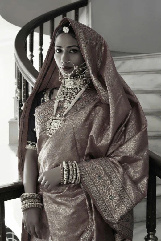 a woman in traditional indian attire standing by stairs