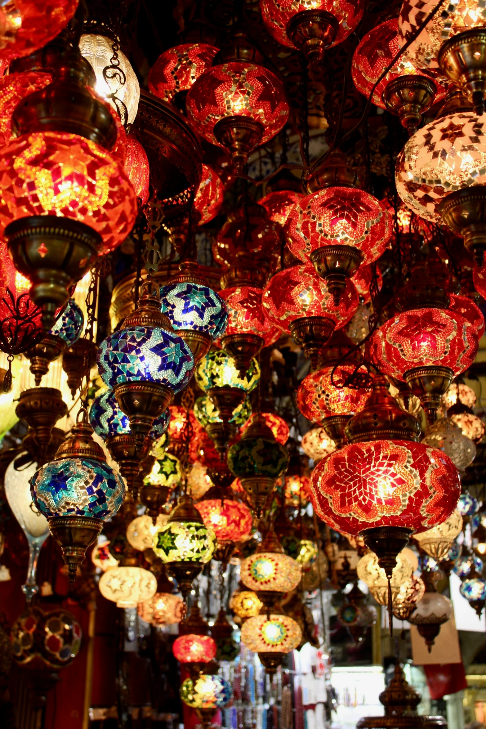 many large red glass lamps hang from a ceiling