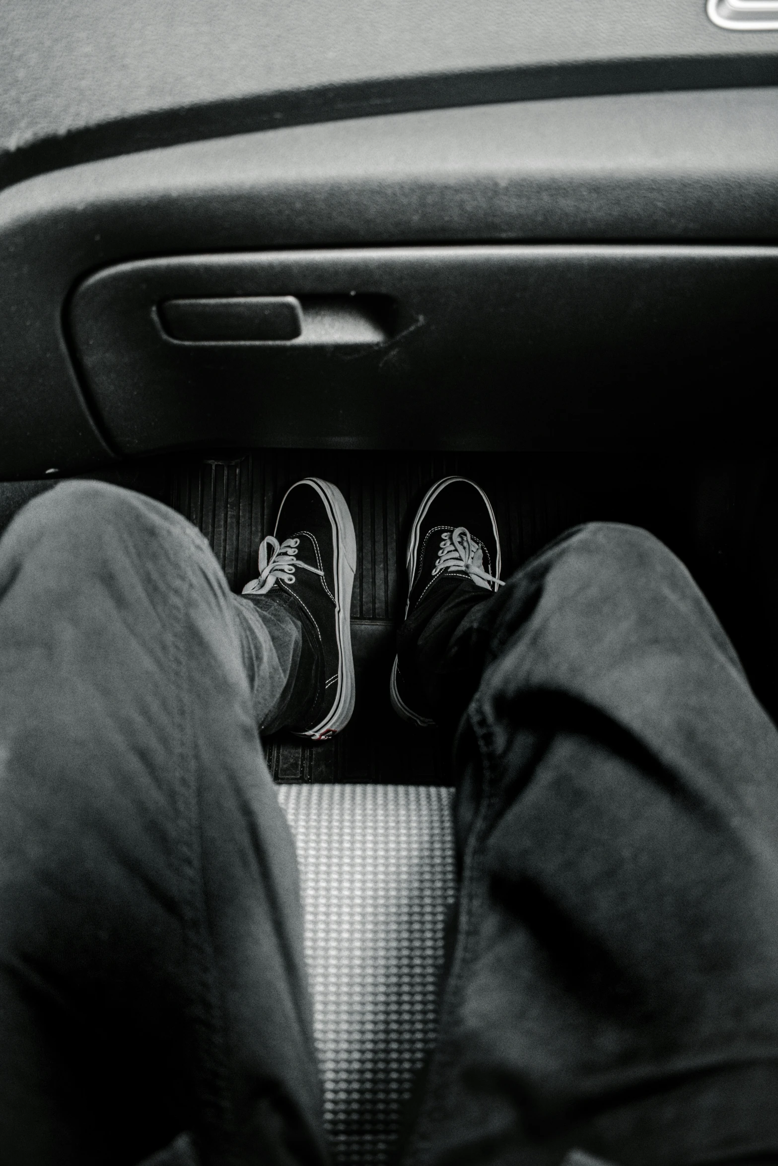 someone's shoes are resting on the floor in the passenger's compartment of a vehicle