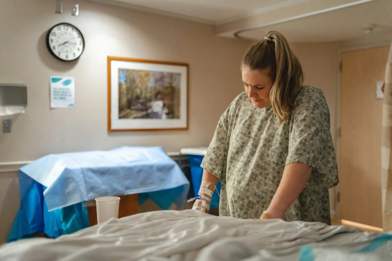 a hospital worker preparing a bed with a blanket