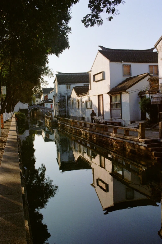 a person on a bike rides by a canal