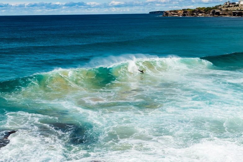 man surfing on surfboard in the ocean next to beach