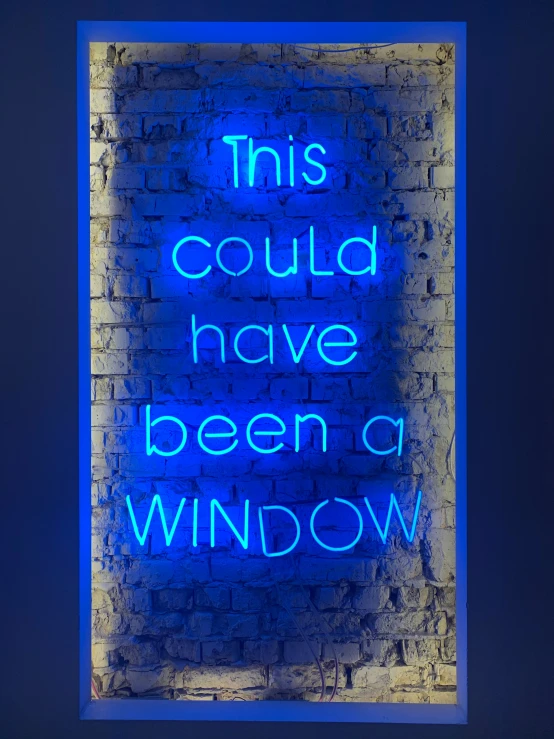 blue neon sign in front of brick wall