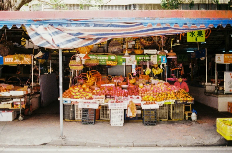 a colorful fruit stand has many fruits under it