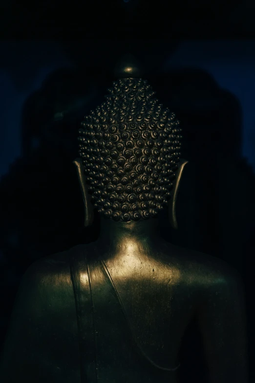 a buddha statue in the dark near a wall