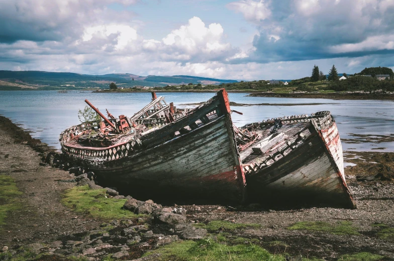 two old ship sitting on land in front of water