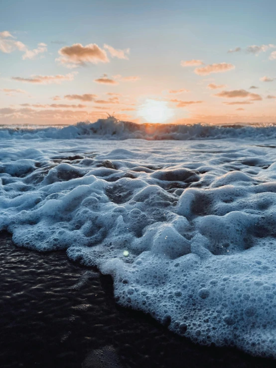 a small patch of land is surrounded by foamy water