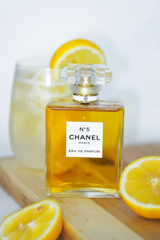 the bottle of chanel no 5 is on a  board with lemons