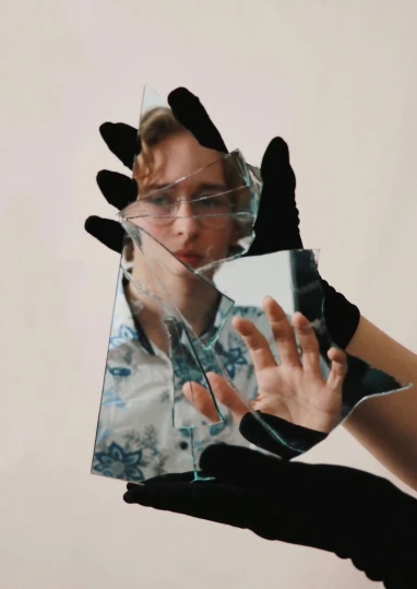 hand with glass reflecting picture of a person
