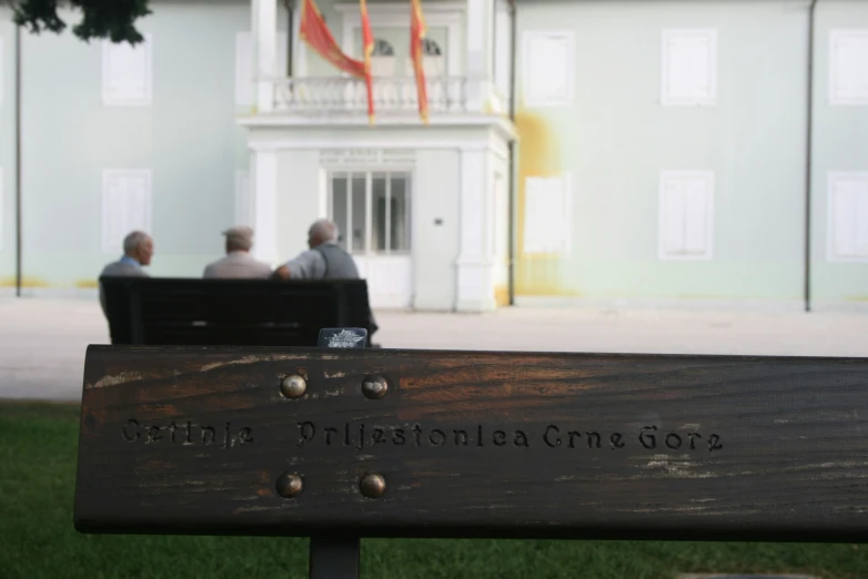 an old wood bench is sitting outside by some people