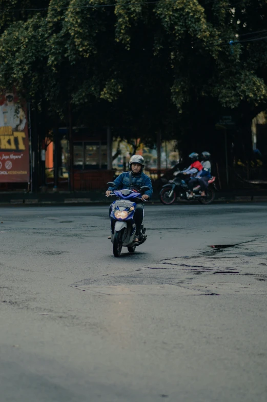 man riding a motorcycle in a city street