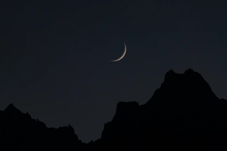 an image of the moon on top of the mountain