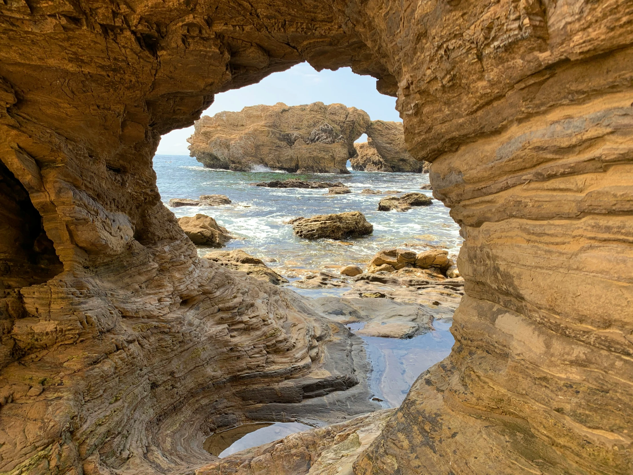 an arch shaped rock formation in the water