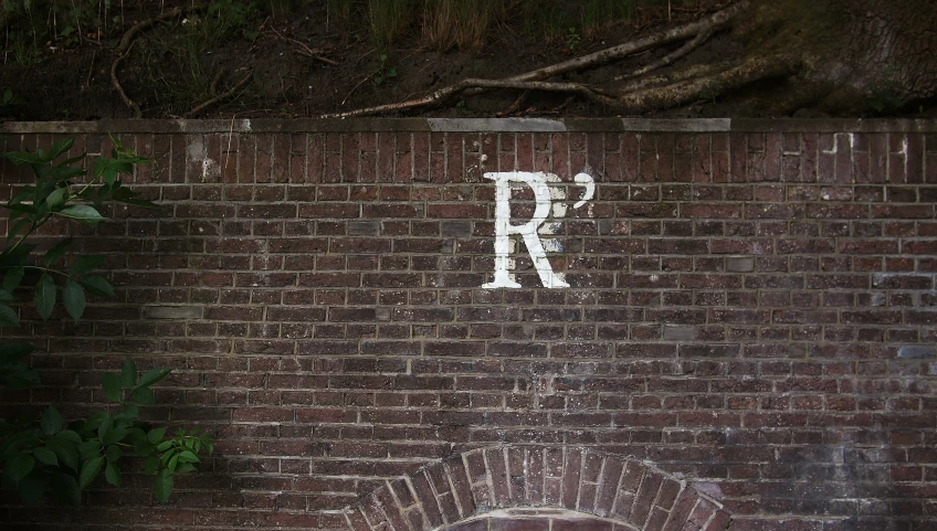 the brick wall has a large baseball bat and sign painted on it