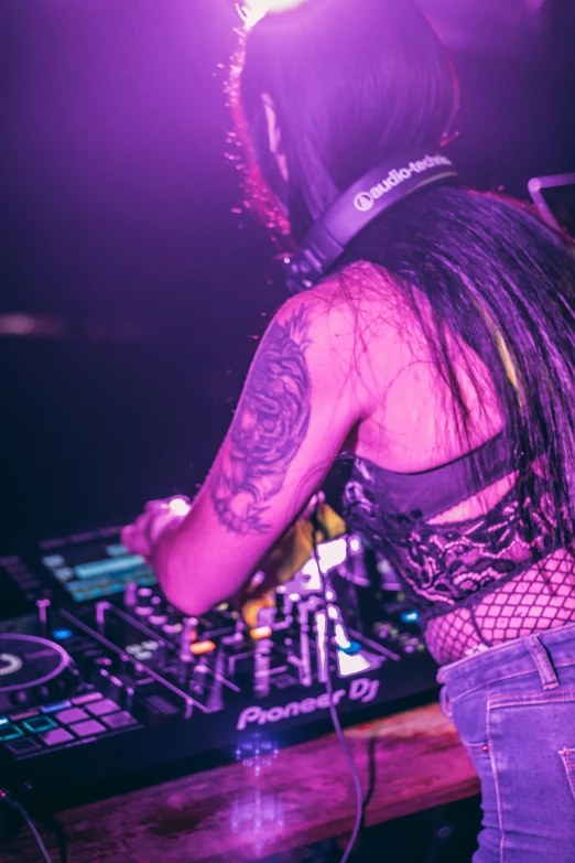 a dj holding up two controllers in front of his set