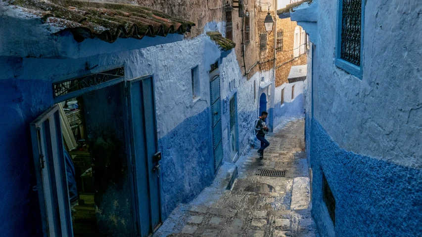 an alley way with people and umbrellas on either side