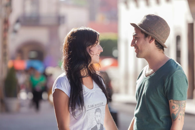 a man and a woman talk and stand together on a sidewalk